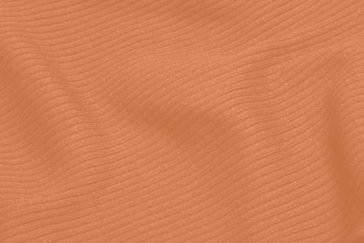 Peach fuzz colour monochrome texture knitted fabric. Peach knitted Jersey as textile background. Monochrome color background. Wool knitting texture. Trendy color 2024. High quality photo