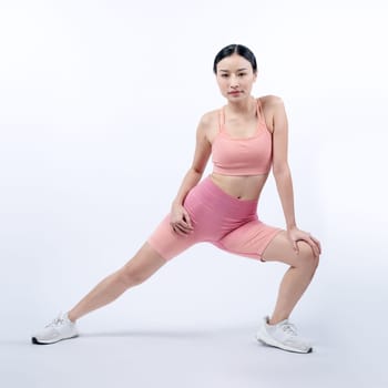 Young attractive asian woman in sportswear stretching before fitness exercise routine. Healthy body care workout with athletic woman warming up on studio shot isolated background. Vigorous