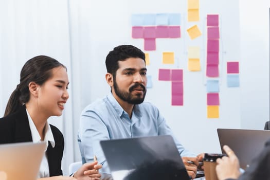 Professional Asian employee work together as team in corporate office, discussing business plans and data to achieve success on desk with laptop. Modern office worker teamwork concept. Concord