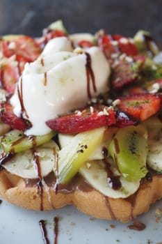 Ice cream and berry fruits with chocolate sauce and waffle.