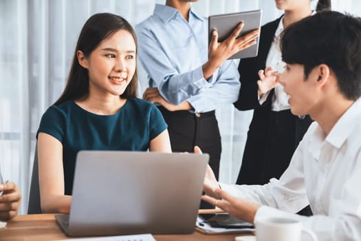 Happy diverse business people work together, discussing in corporate office. Professional and diversity teamwork discuss business plan on desk with laptop. Modern multicultural office worker. Concord