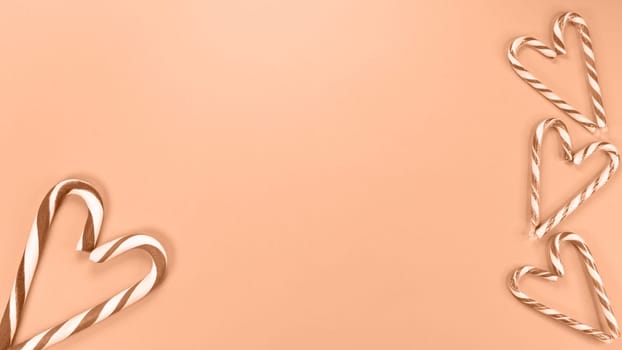 Heart shaped with Candy cane sweets. Image toned in Peach Fuzz color of the year 2024. St Valentine Day, Love