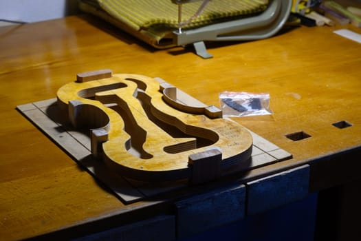 artisan violin maker luthier working on violin center bot, corner blocks , bend ribs for a new classic handmade violin using mold