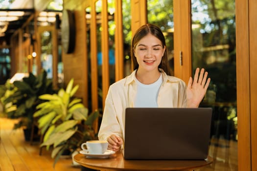 Young woman working on laptop at outdoor cafe garden during springtime, enjoying serenity ambient at coffee shop. Digital nomad freelancer or college student working remotely or blogging. Expedient