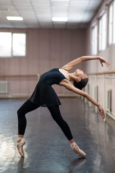 Asian woman dancing in ballet class. Bending in the back