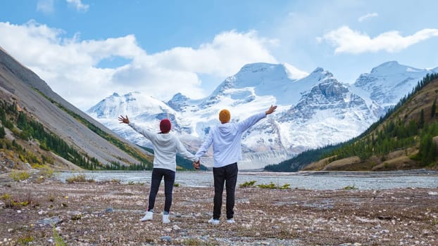 Icefields Parkway with autumn trees and snowy foggy mountains in Jasper Canada Alberta. couple of men and women on a road trip at Icefield Parkway Canadian Rockies