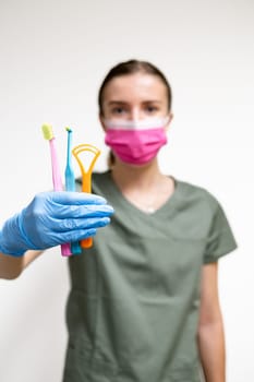 Different toothbrushes and interdental toothbrushes in dentist hand.