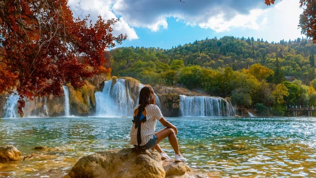 KRKA Waterfalls Croatia during summer, young Asian women watch the waterfalls of Krka National Park Croatia on a bright summer evening in the park.