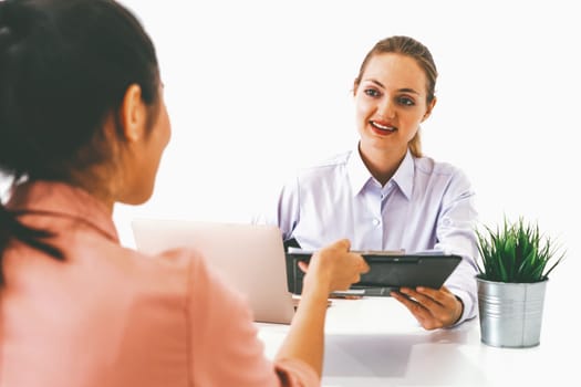 Two young business women in meeting at office table for job application and business agreement. Recruitment and human resources concept. uds