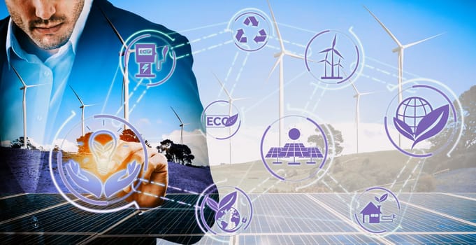 Double exposure graphic of business people working over wind turbine farm and green renewable energy worker interface. Concept of sustainability development by alternative energy. uds