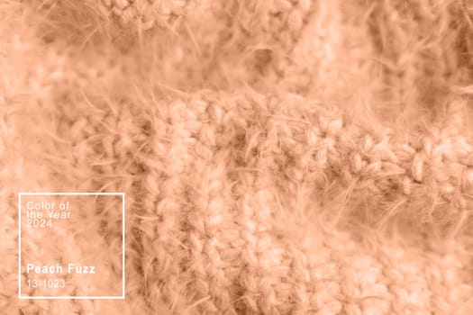Peach fuzz, color of the year 2024, knitwear texture. Soft texture of homemade cashmere wool toned on peach fuzz color