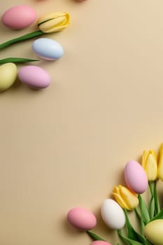 Colorful tulips and eggs lying on teal beige background with copy space for easter celebration