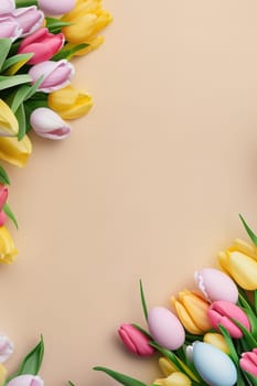 Colorful tulips and eggs lying on teal beige background with copy space for easter celebration