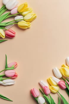 Colorful tulips and eggs lying on teal beige background with copy space for easter celebration