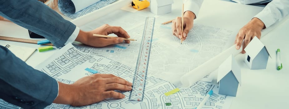 Worker, architect and engineer work on real estate construction project oratory planning with cartography and cadastral map of urban town area to guide to construction developer business plan of city