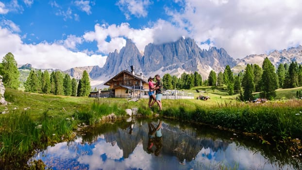 A couple of men and women at Geisleralm Rifugio Odle Dolomites Italy, men and woman hiking in the mountains of Val Di Funes in Italian Dolomites in Puez Odle Nature Park