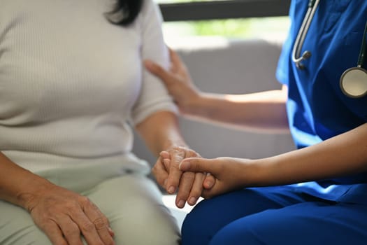 Cropped shot of doctor holding senior woman hand for hope and supporting. Elderly healthcare concept.