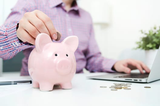 Man putting coin in piggy bank. saving money, budget, investment, finance concept