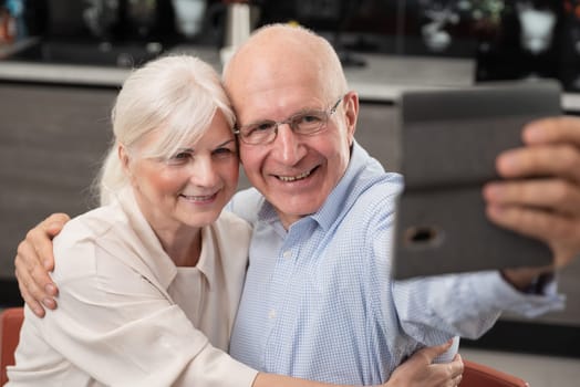 Cheerful senior couple taking selfie at home