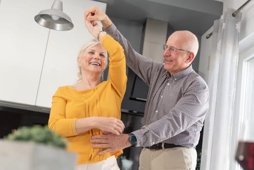 Senior couple dancing and smiling at home. Happy couple of pensioners