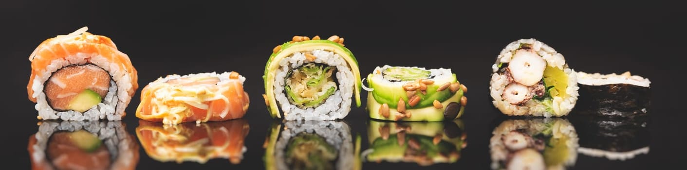 Sushi roll set on black glass background. Japanese Asian traditional food front view