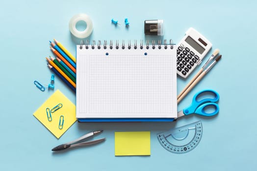 Back to school, stationery on blue background. Image with copy space.