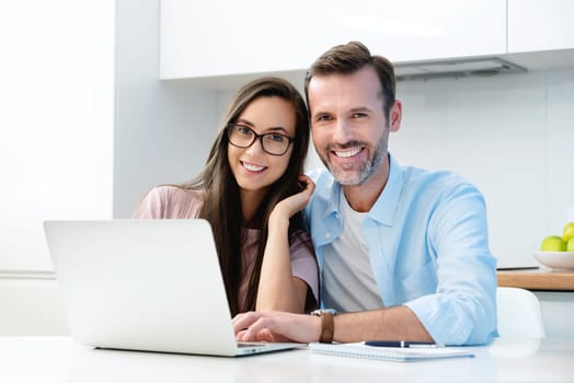 Smiling couple sitting at the computer. Financial concept, beautiful white smile