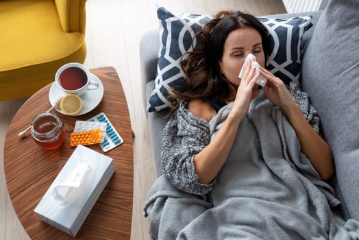 Sick woman in bed, blowing her nose. Health care concept