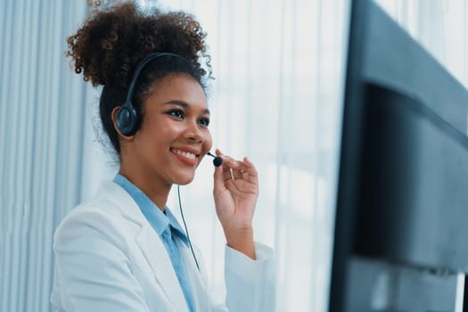 African American young businesswoman wearing headset working in office to support remote crucial customer or colleague. Call center, telemarketing, customer support agent provide service on video call