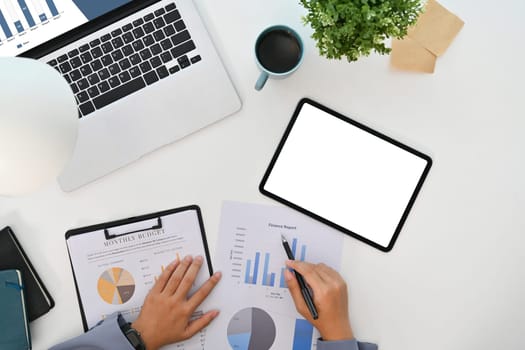 Businesswoman analyzing statistics, working with financial graphs charts on white office desk.