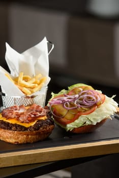 fresh tasty burger and french fries on wooden desk.