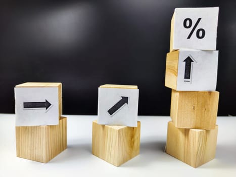 Wooden cubes with arrows and percentages on black background. Stages of action and goal achievement. Planning. Business actions. Receiving income and profit