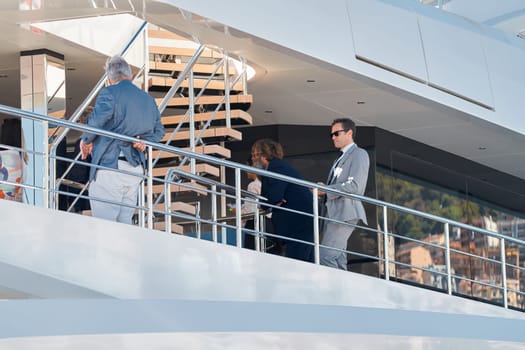 Monaco, Monte Carlo, 27 September 2022 - Invited wealthy clients inspect megayachts at the largest fair exhibition in the world yacht show MYS, port Hercules, yacht brokers, sunny weather. High quality photo