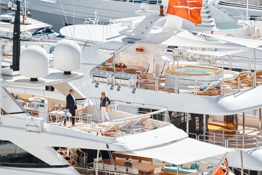 Monaco, Monte Carlo, 27 September 2022 - Invited wealthy clients inspect megayachts at the largest fair exhibition in the world yacht show MYS, port Hercules, yacht brokers, sunny weather. High quality photo