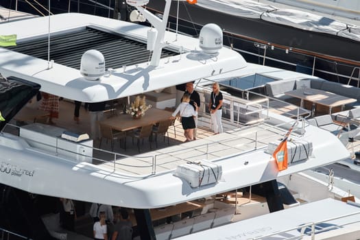 Monaco, Monte Carlo, 27 September 2022 - Invited wealthy clients inspect megayachts at the largest fair exhibition in the world yacht show MYS, port Hercules, yacht brokers, sunny weather. High quality photo