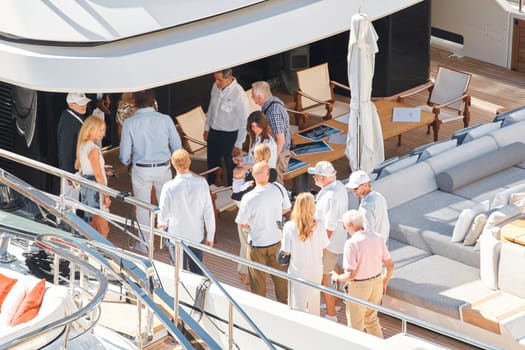 Monaco, Monte Carlo, 27 September 2022 - Invited wealthy clients inspect megayachts at the largest fair exhibition in the world yacht show MYS, port Hercules, yacht brokers, sunny weather. High quality photo