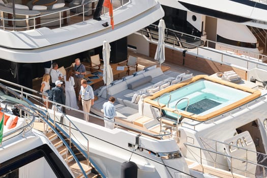 Monaco, Monte Carlo, 27 September 2022 - Invited wealthy clients inspect megayachts at the largest fair exhibition in the world yacht show MYS, port Hercules, yacht brokers, sunny weather. High quality photo