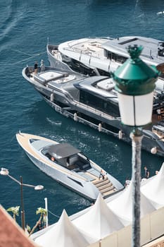 Monaco, Monte Carlo, 27 September 2022 - Invited wealthy clients inspect megayachts at the largest fair exhibition in the world yacht show MYS, port Hercules, yacht brokers, sunny weather. High quality photo