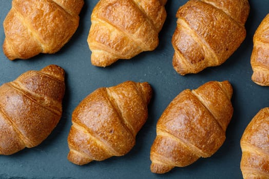 Croissants on a dark board.