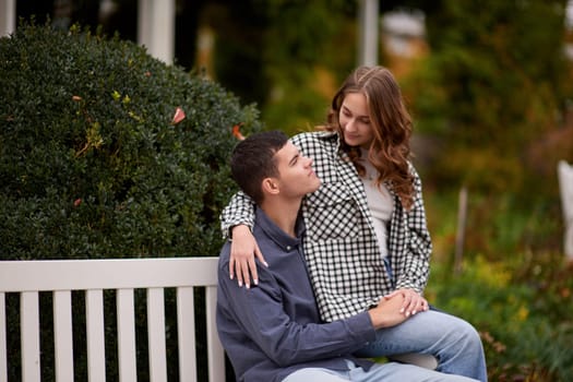 lovely young couple kissing outdoors in autumn. Loving couple walking in nature. Autumn mood. Happy man and woman hugging and kissing in autumn. Love. Fashionable couple outdoors. Fashion, people and lifestyle. Stylish couple in autumn outfit.