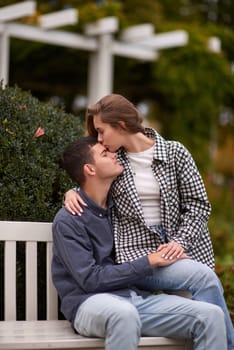 lovely young couple kissing outdoors in autumn. Loving couple walking in nature. Autumn mood. Happy man and woman hugging and kissing in autumn. Love. Fashionable couple outdoors. Fashion, people and lifestyle. Stylish couple in autumn outfit.