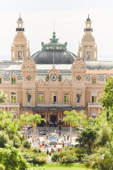 Monaco, Monte-Carlo, 21 October 2022 - Square Casino Monte-Carlo at sunny day, wealth life, tourists take pictures of the landmark, pine trees, blue sky. High quality photo