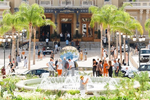 Monaco, Monte-Carlo, 21 October 2022 - Square Casino Monte-Carlo at sunny day, wealth life, tourists take pictures of the landmark, pine trees, blue sky. High quality photo