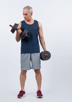 Full body length shot active and sporty senior man lifting dumbbell during weight training workout on isolated background. Healthy active physique and body care lifestyle for pensioner. Clout