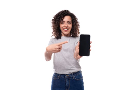 well-groomed european woman with natural black curly hair in a gray basic t-shirt on a white background.