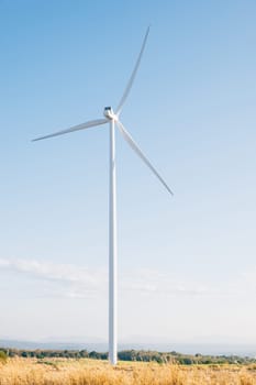 A winter windmill farm on a mountain harnesses clean wind energy with efficient turbines. Innovative technology drives sustainable development under the vast blue sky.