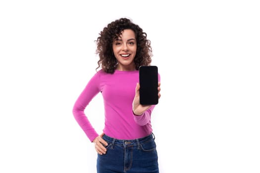 young charming woman with stylish curly hair styling shows smartphone screen.