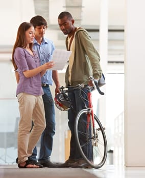 People, talking and document in office with bicycle for travel or morning commute to workplace. Bike messenger, paper and discussion of business, logistics or checklist with employees or clients.