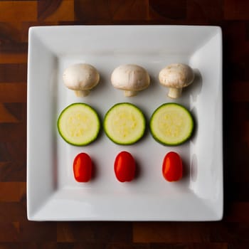 Fresh and Vibrant Vegetable Medley on a Wooden Table - a symmetrical arrangement of button mushrooms, sliced zucchini, and grape tomatoes, perfect for culinary websites, health blogs, and vegetarian cuisine.