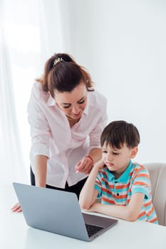 Female teaches boy to work on computer online